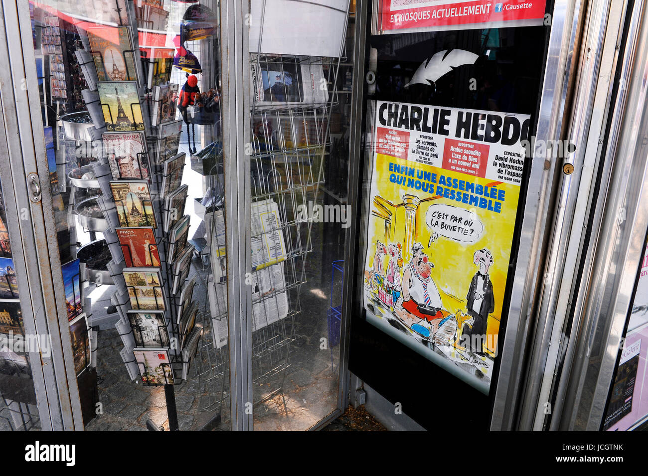 a French newspaper kiosk displaying an issue of the satirical weekly magazine Charlie Hebdo (specifically No. 1299 from June 2017) Stock Photo