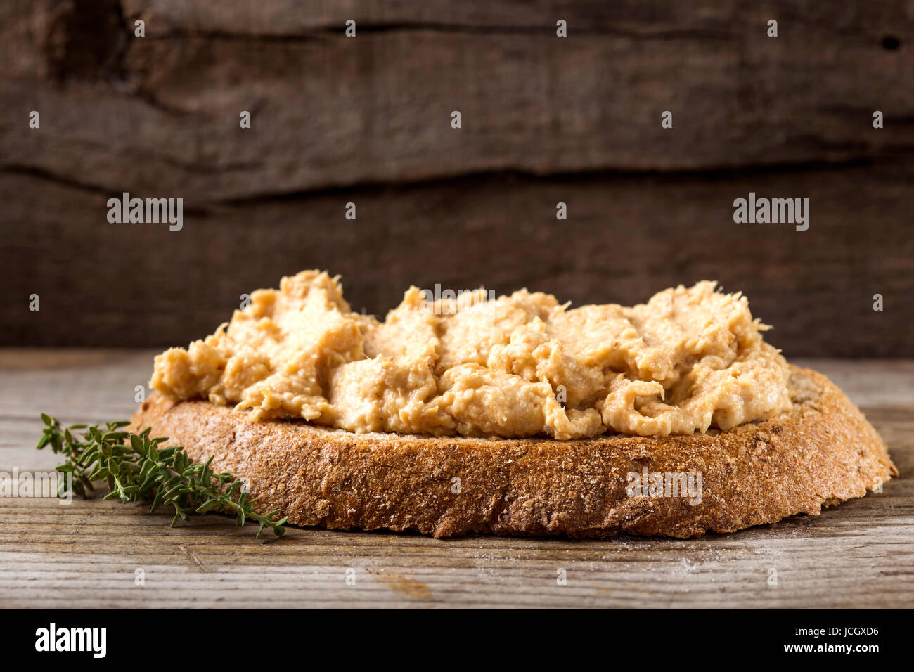 Fresh homemade chicken liver pate on bread over rustic background Stock Photo