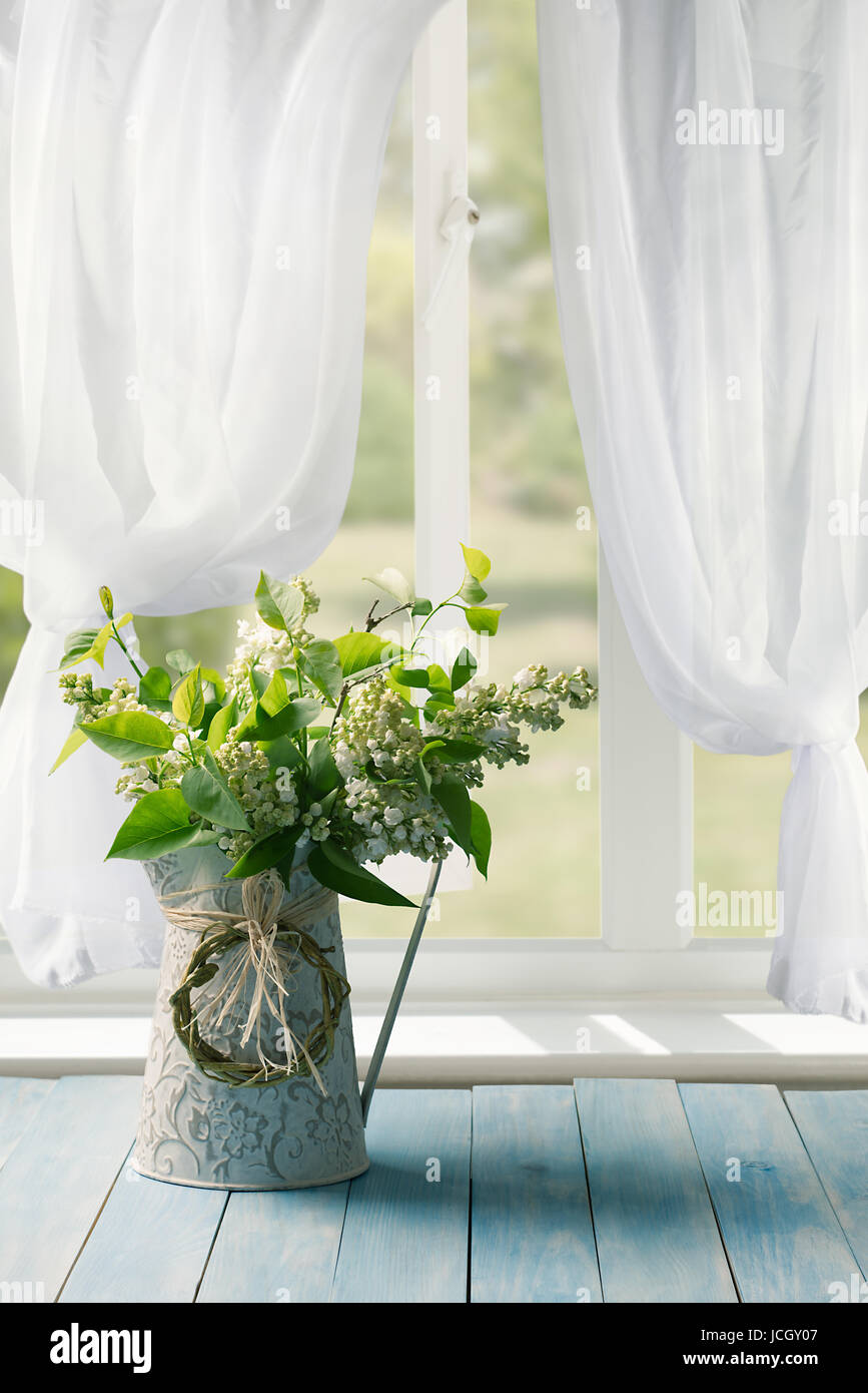 Lilac flowers in jug in the window of a country house Stock Photo