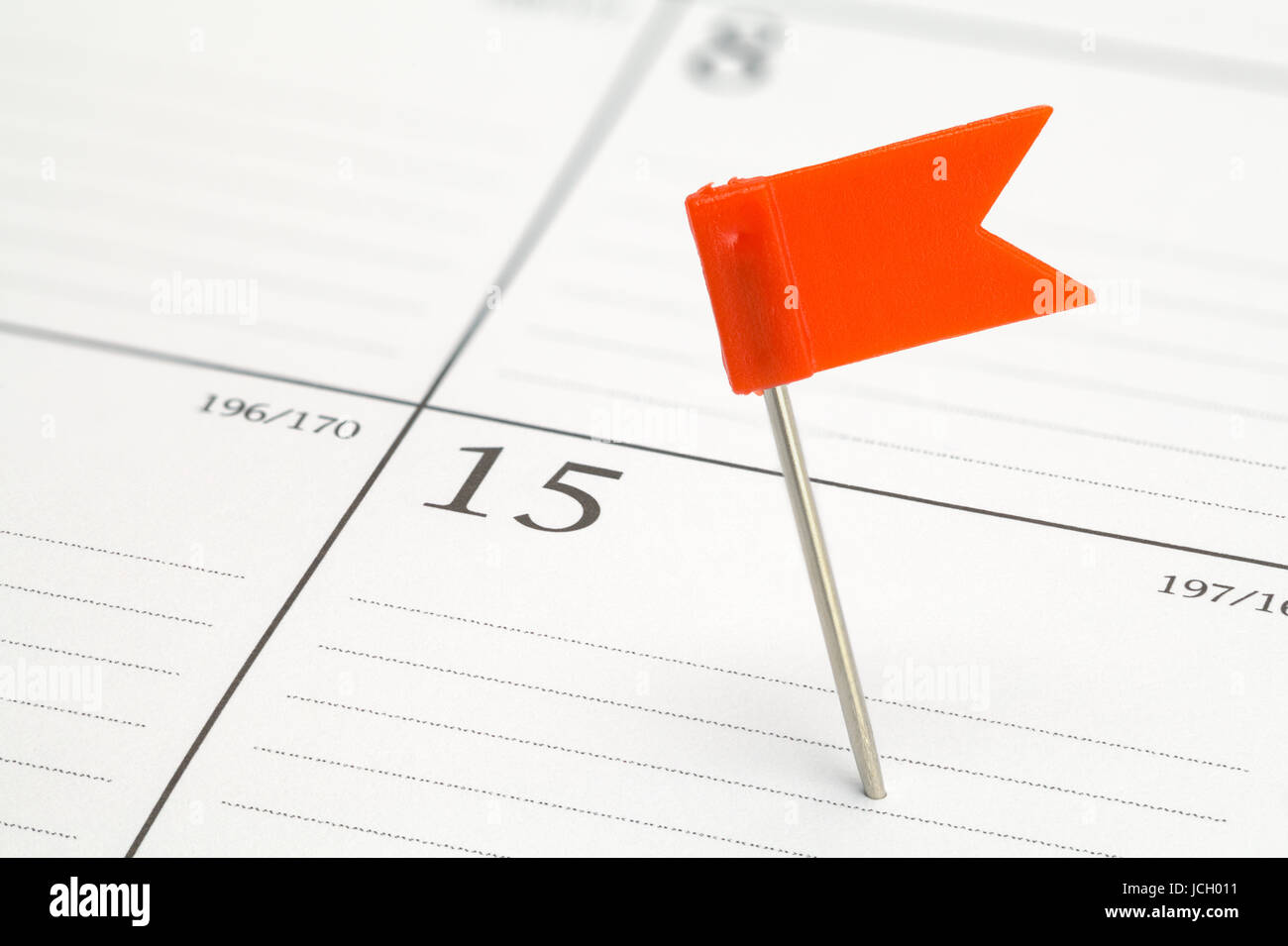 Red Flag Pin Stuck in Calendar Date. Stock Photo