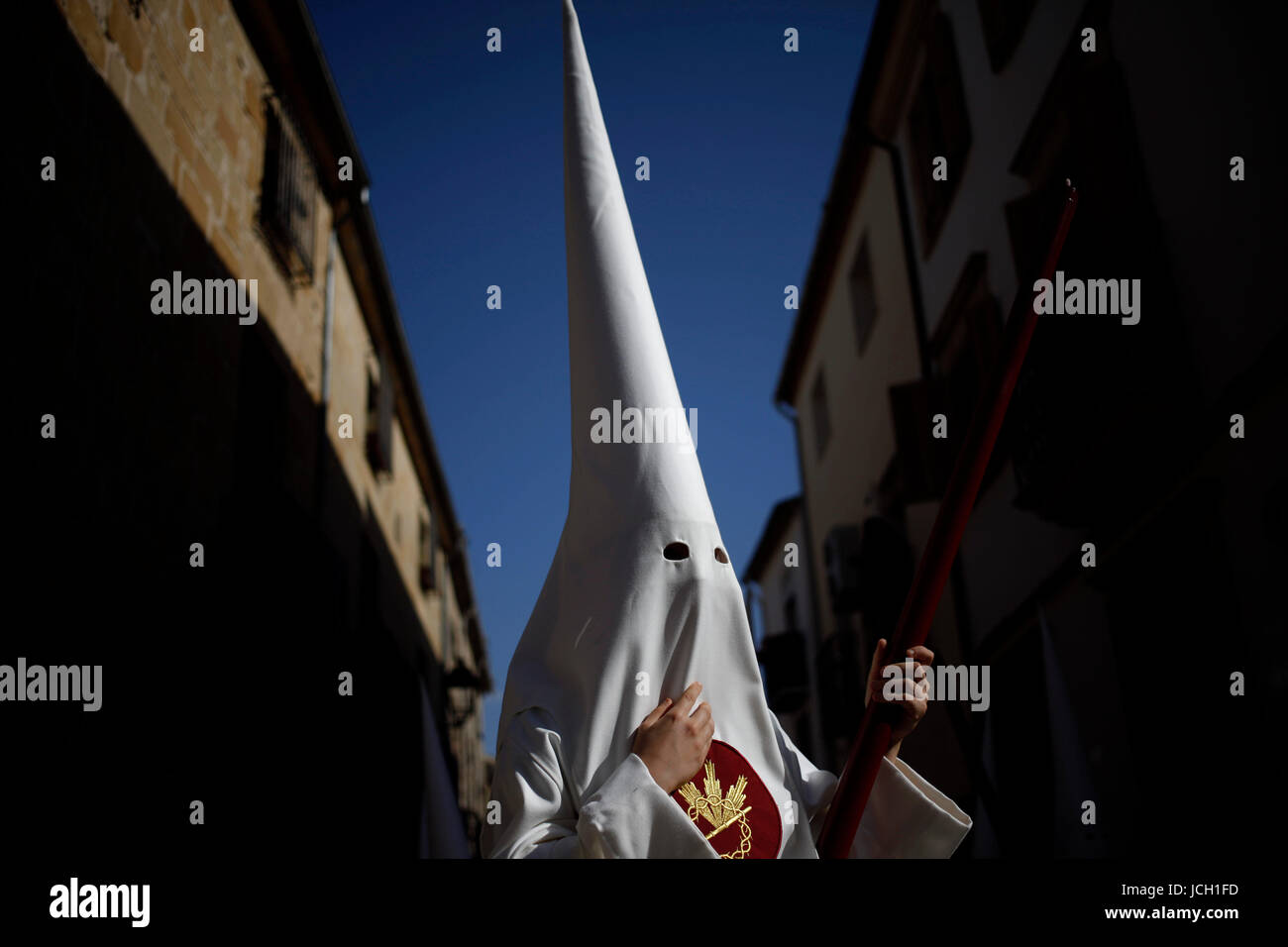 A penitente wearing a white pointer hood during Easter Week celebrations in Baeza, Jaen Province, Andalusia, Spain Stock Photo