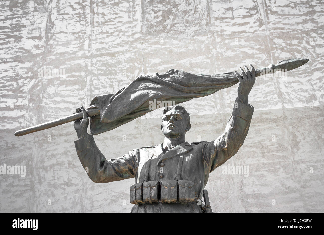 Bronze of an italian soldier statue with rolled up flag Stock Photo