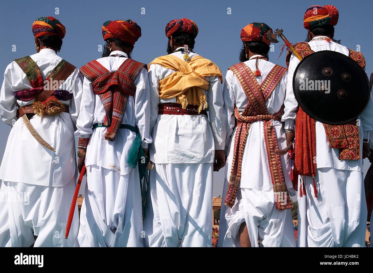 Men in traditional Rajasthani dress with shields and axes at the annual