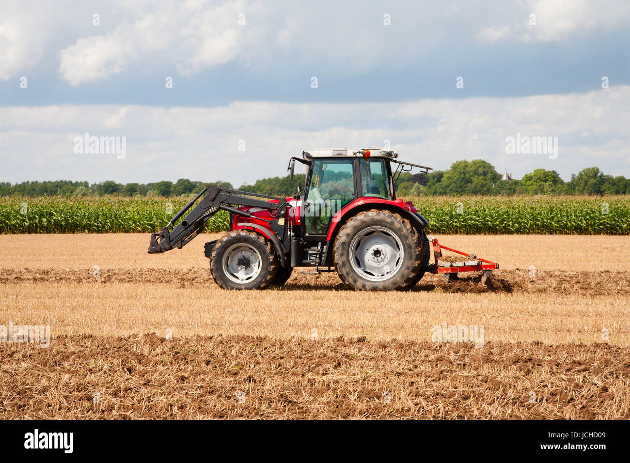 Tractor with plow in the field Stock Photo - Alamy