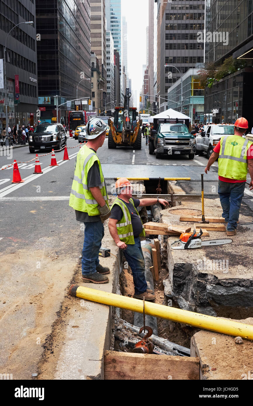 NEW YORK CITY - OCTOBER 15, 2014: construction workers doing repair work on supply lines in the underground of Madison Avenue Stock Photo