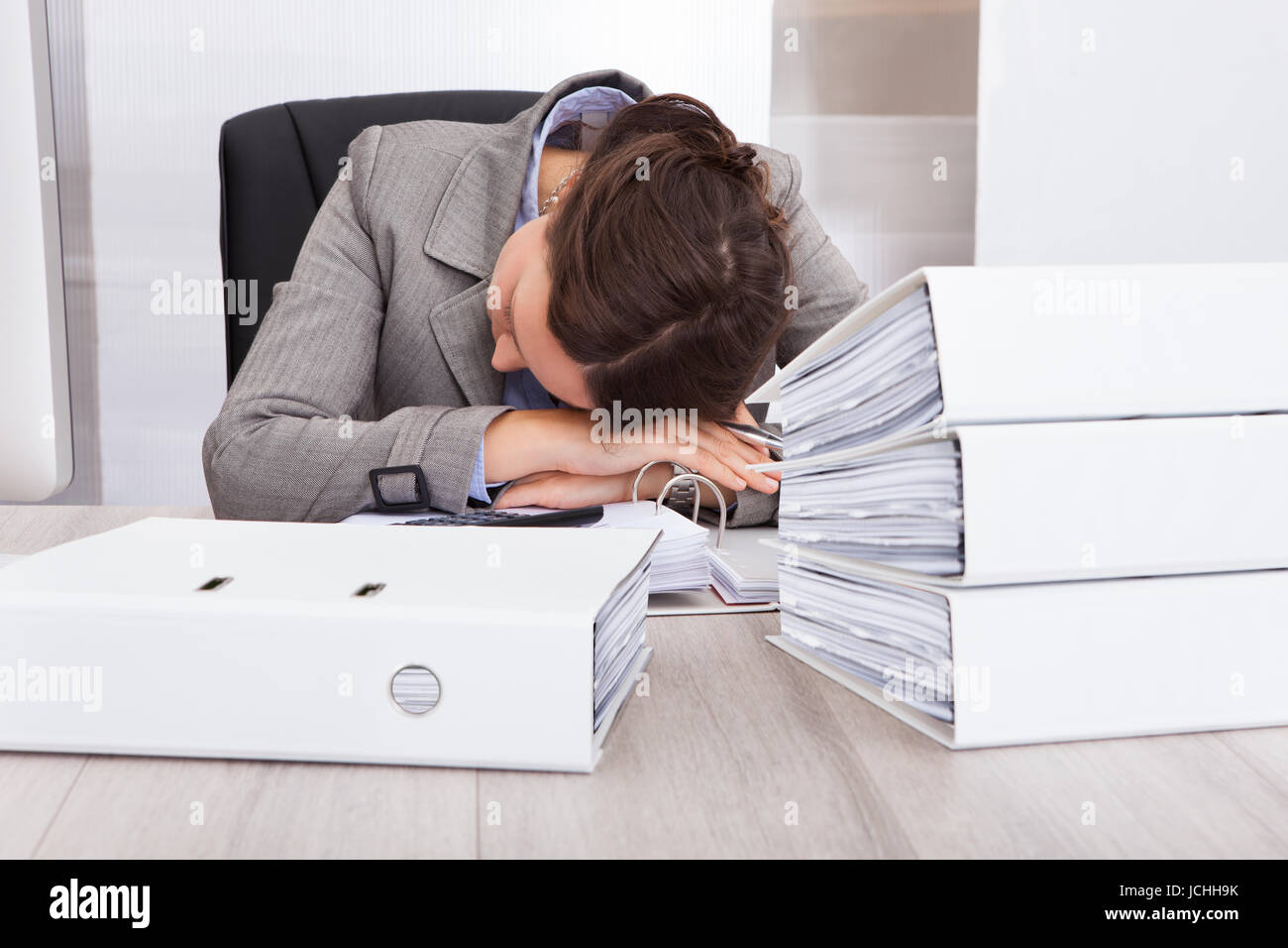 Portrait Of Exhausted Businesswoman Sleeping On Desk Stock Photo - Alamy