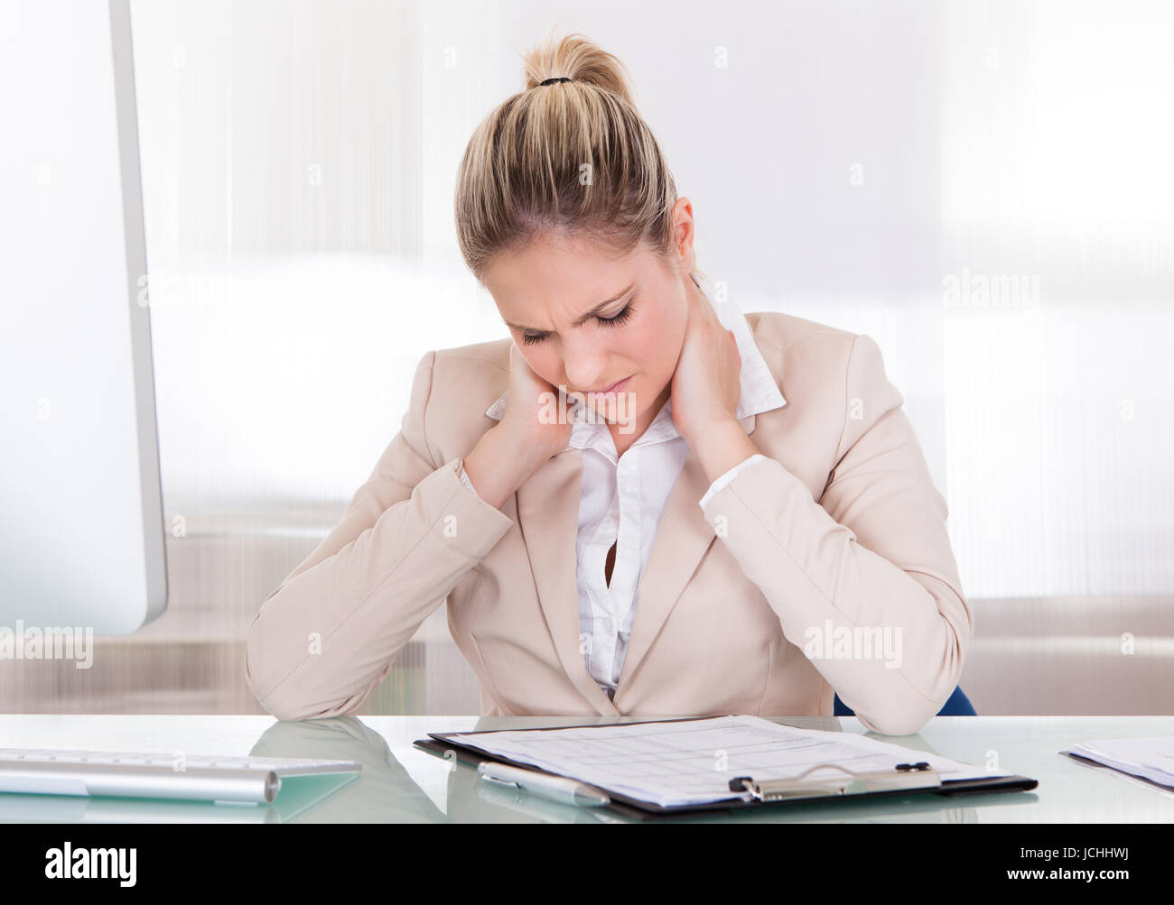 Young Businesswoman Suffering From Neck Pain At Office Stock Photo - Alamy