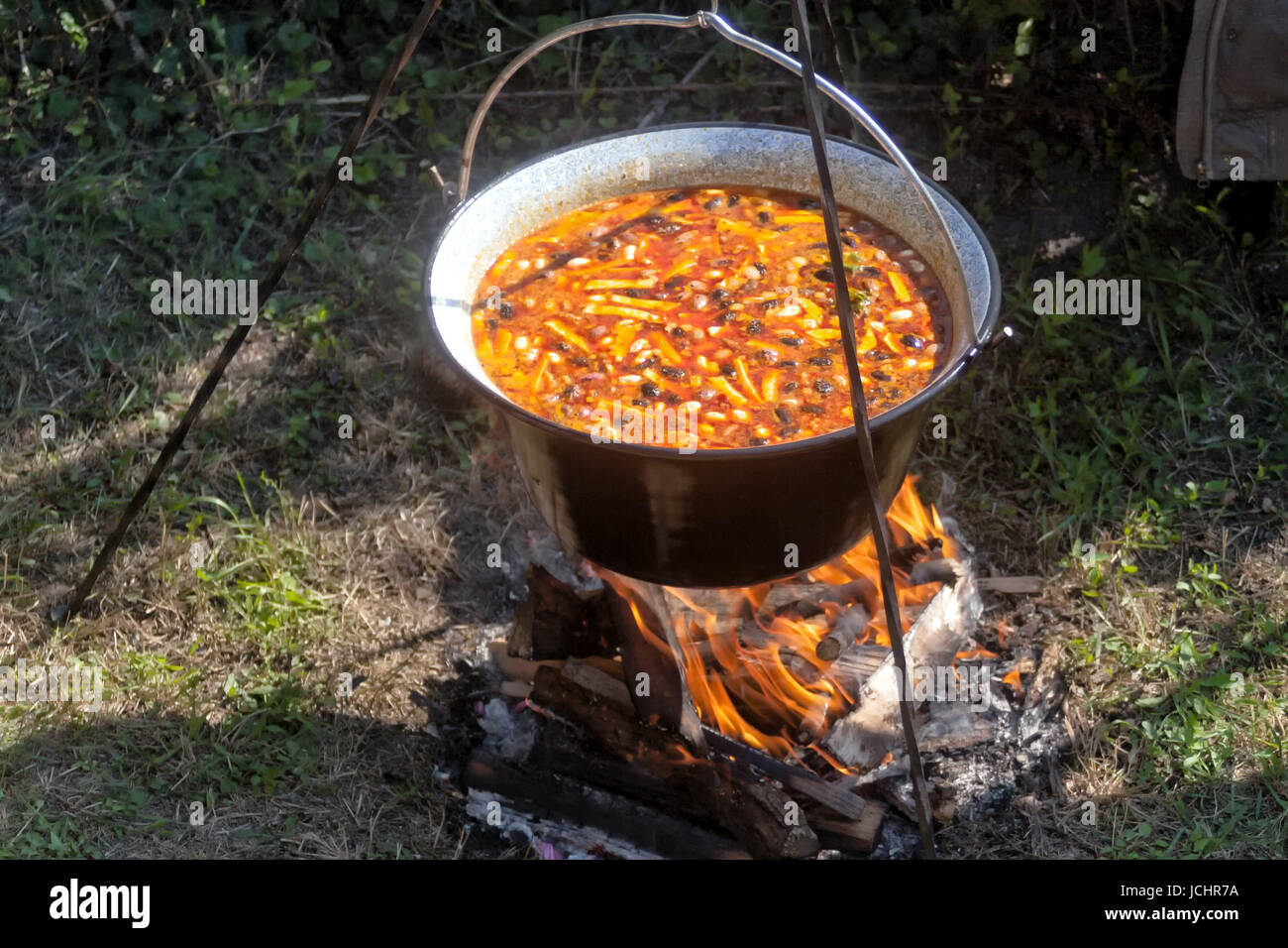 Cooking bean goulash in a caldron on open flame Stock Photo