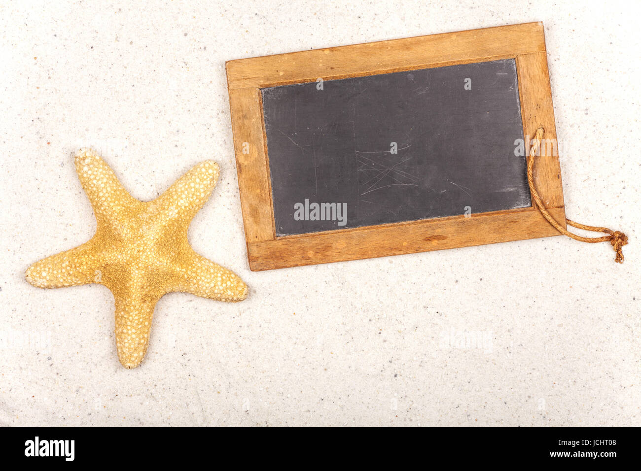 Leere Schiefertafel mit Seestern im Sand Stock Photo