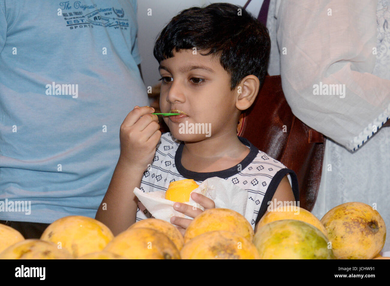 Kolkata, India. 15th June, 2017. Indian boy eats mango at Bengal Mango
