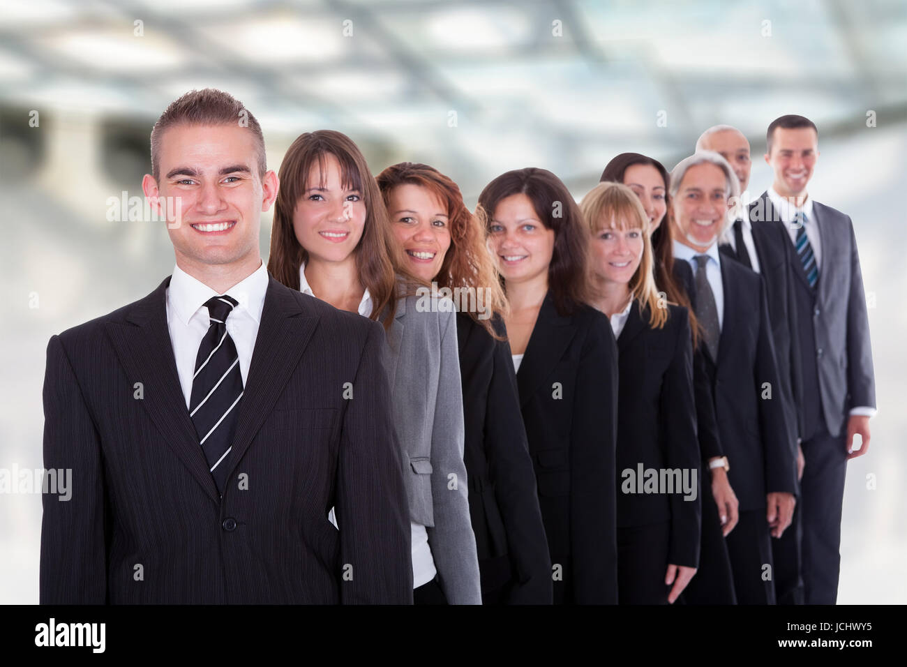 Happy Group Of Businesspeople Standing In A Row Stock Photo - Alamy