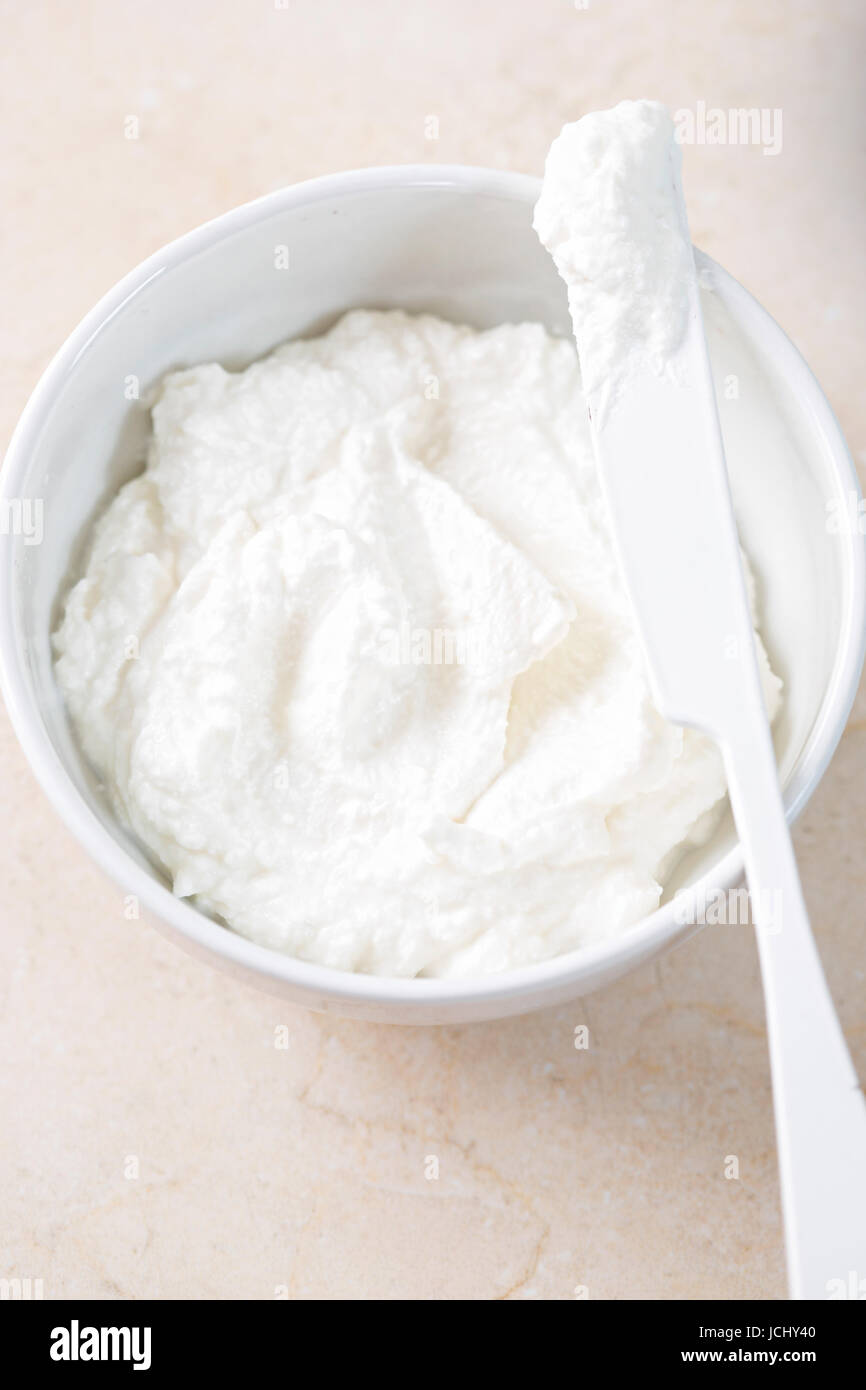 Fresh ricotta cheese in bowl with knife Stock Photo Alamy
