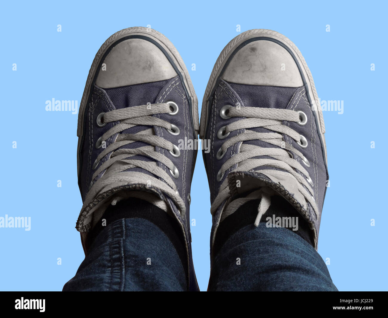 some feet with sneakers in front of blue sky Stock Photo