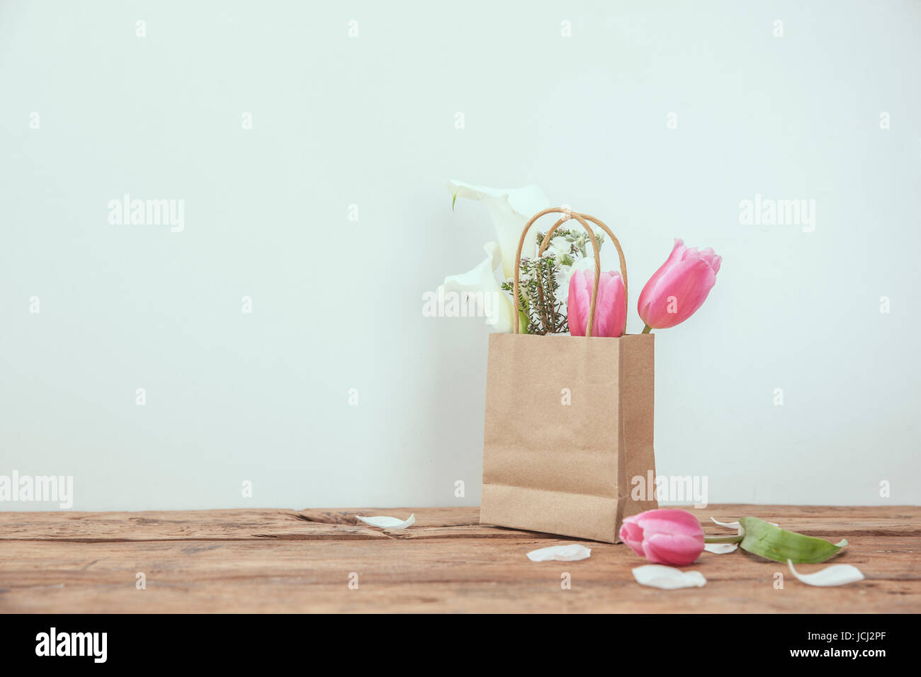 Pink tulips and plants in shopping bag Stock Photo