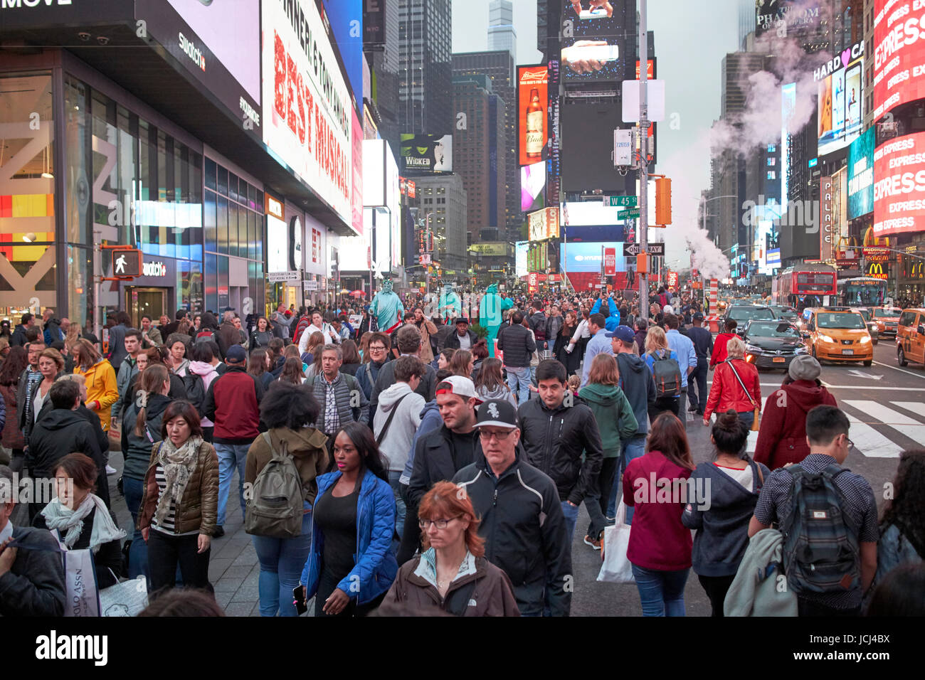 full busy sidewalk in the evening evening in Times Square New York City USA Stock Photo