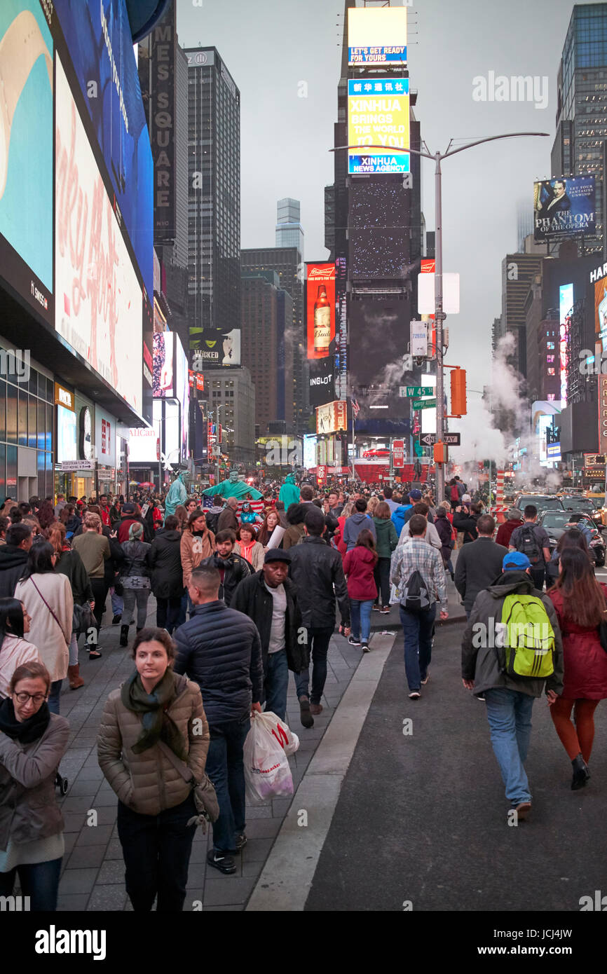 full busy sidewalk in the evening evening in Times Square New York City USA Stock Photo