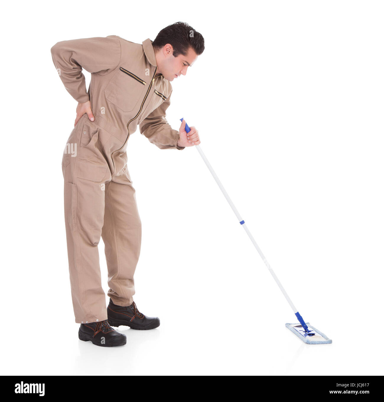 Portrait Of Young Male Worker Suffering From Back Pain Holding Mop