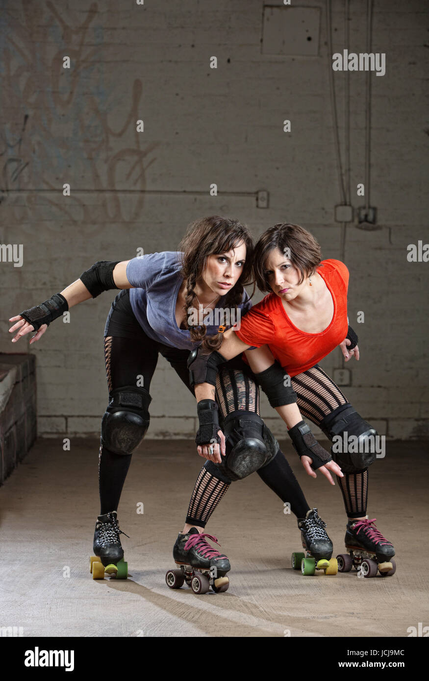 Pair of beautiful female roller derby skaters in action pose Stock Photo -  Alamy