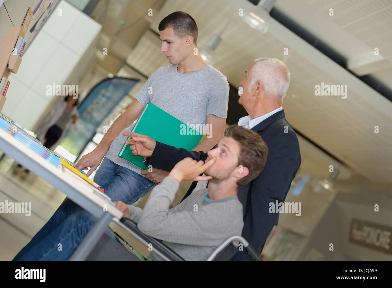 smiling teacher with two students in classroom Stock Photo - Alamy