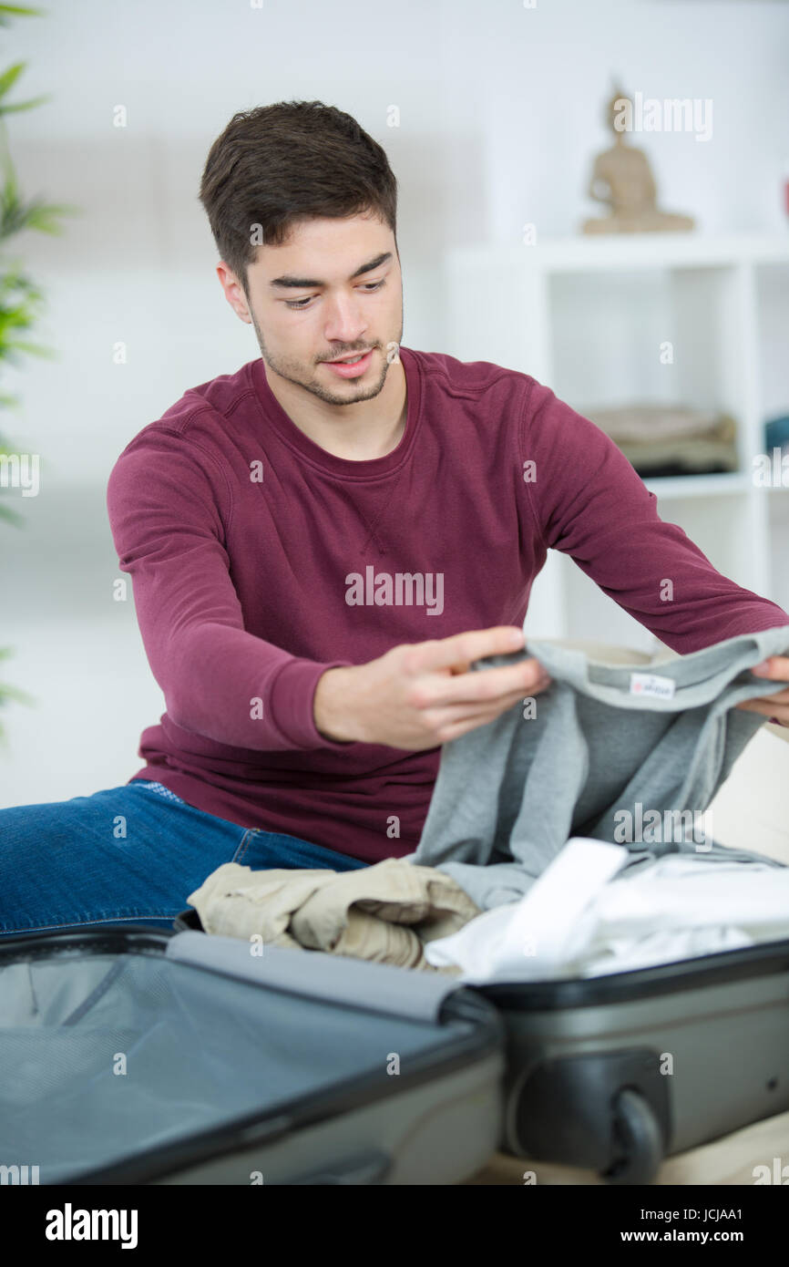 young man packing his bag and preparing for traveling Stock Photo Alamy