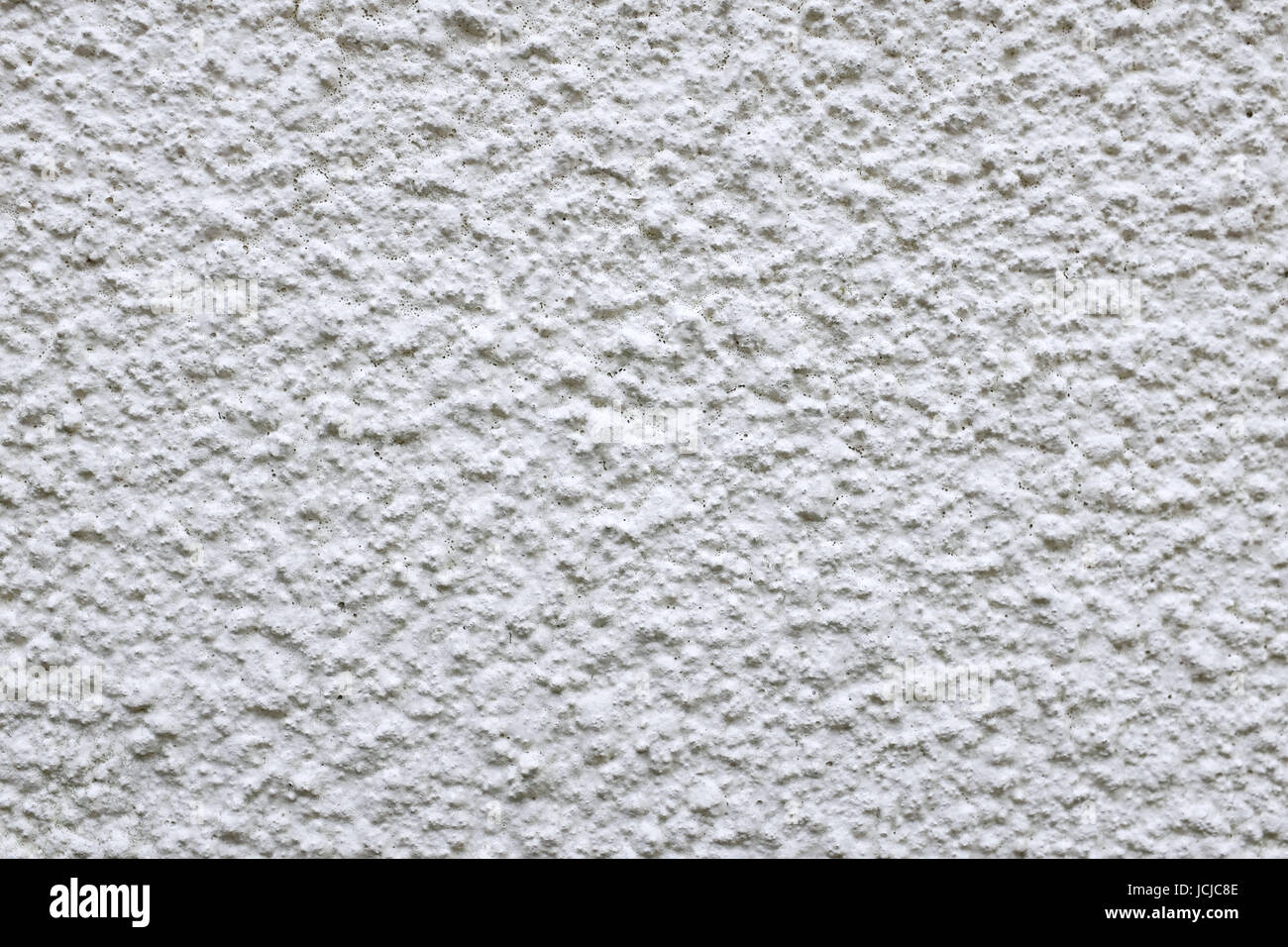 Wall of rough cement render painted white as an abstract background