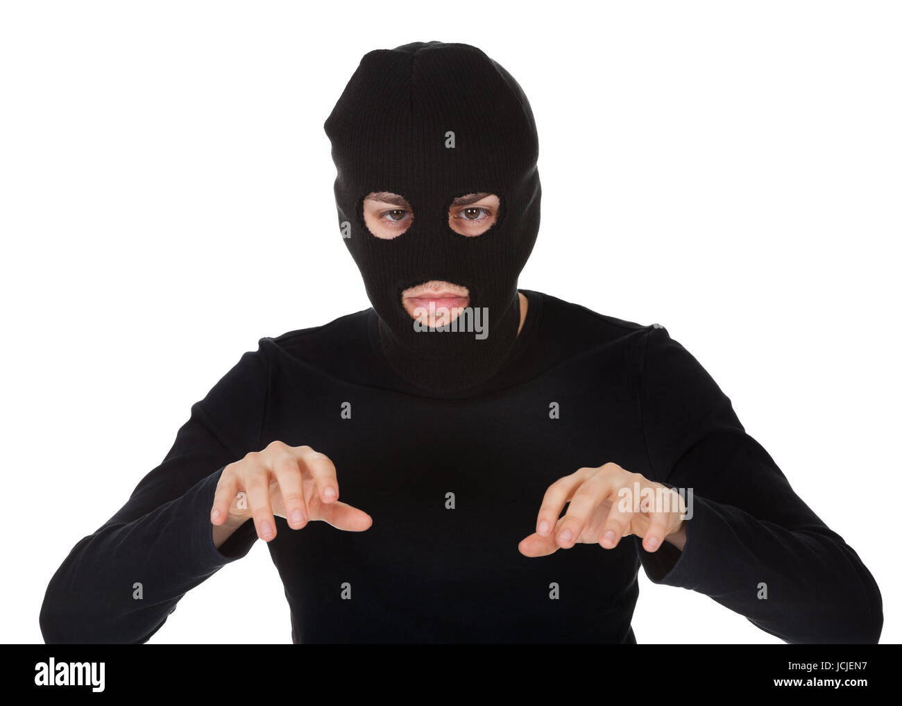 Thief wearing a balaclava dressed in blacked moving stealthily