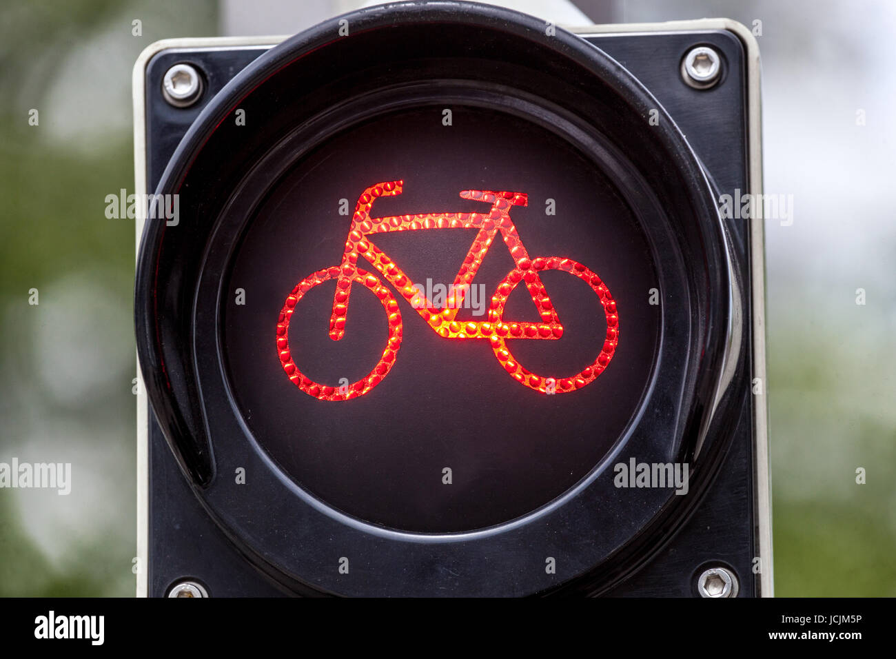 Red colored traffic light with bike sign for cyclists close up., Kassel