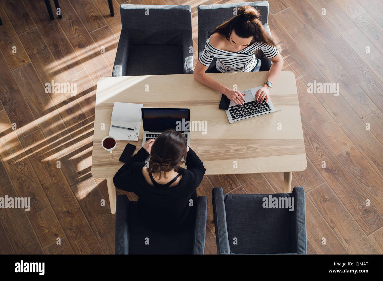 Top view shot of two women looking at each other and laughing with