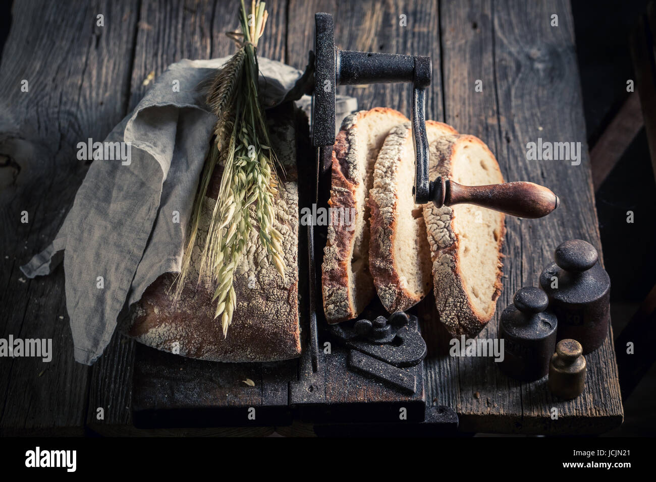 https://c8.alamy.com/comp/JCJN21/fresh-loaf-of-bread-on-old-slicer-JCJN21.jpg