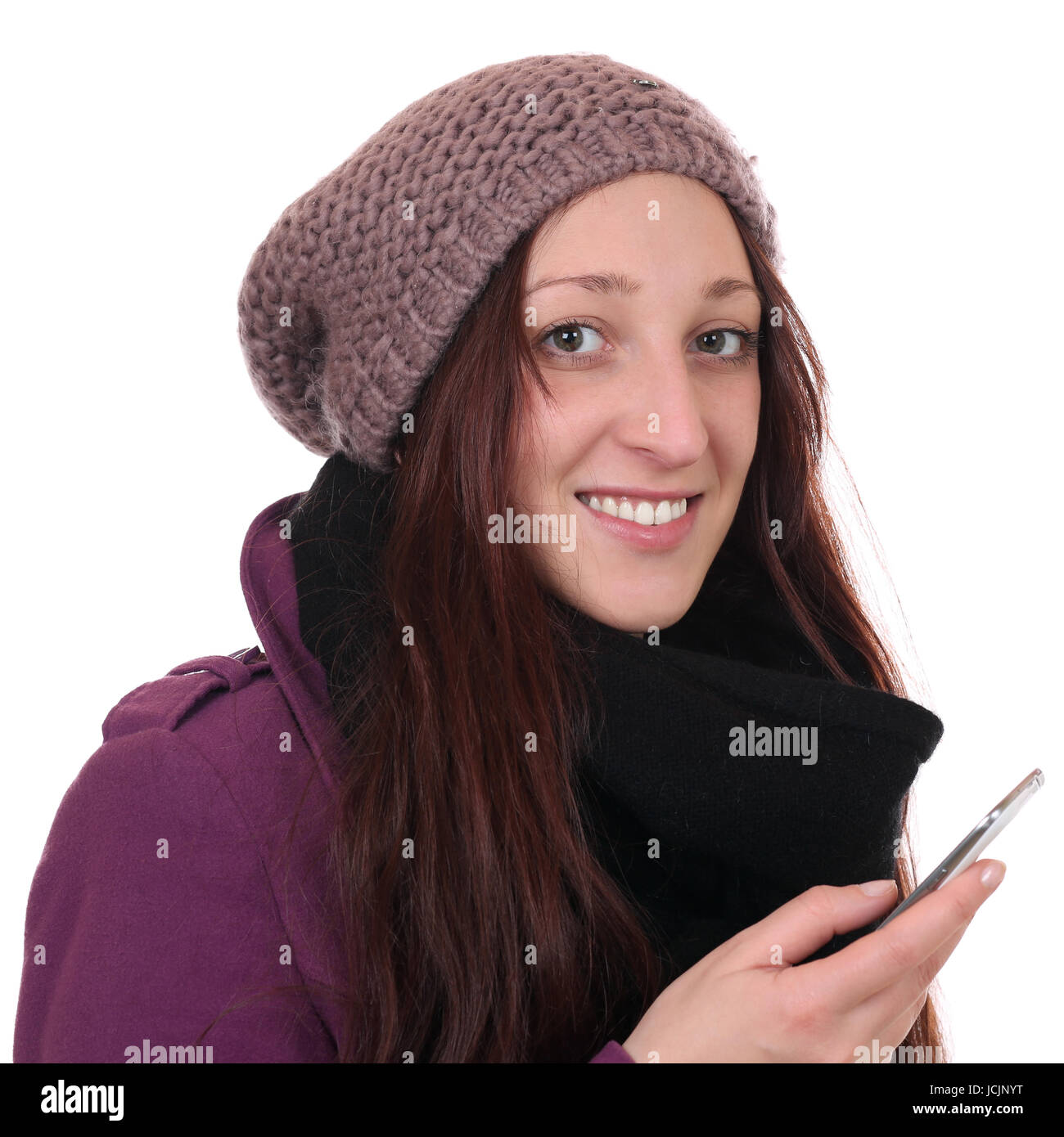 Junge Frau im Winter beim Telefonieren mit Smartphone oder Handy, isoliert vor einem weissen Hintergrund Stock Photo