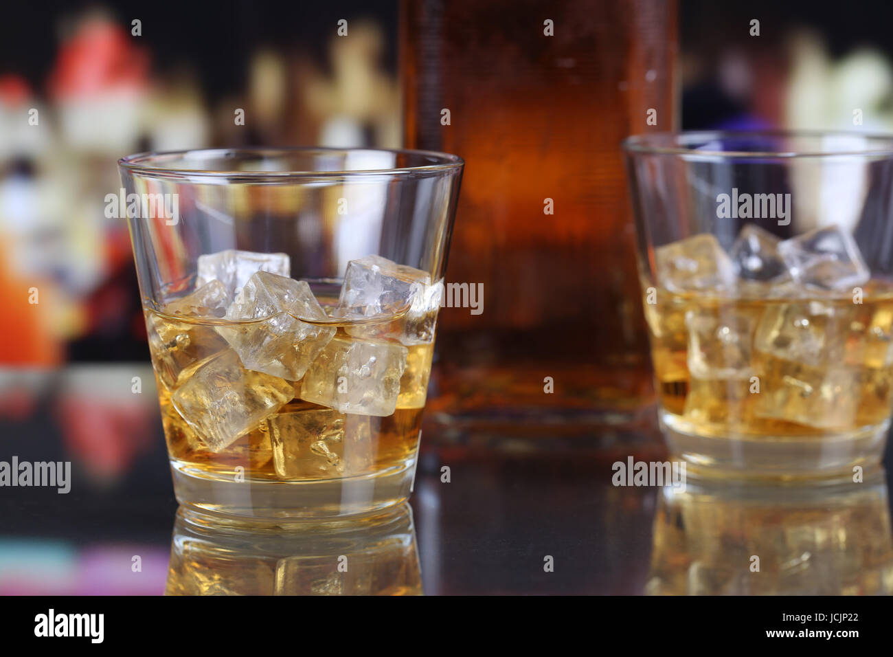 Whisky oder Whiskey im Glas mit Eiswürfeln auf dem Tresen Stock Photo