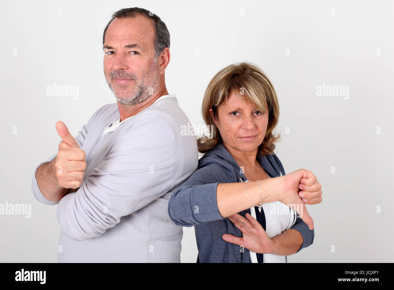 Senior couple with thumbs up and down Stock Photo - Alamy