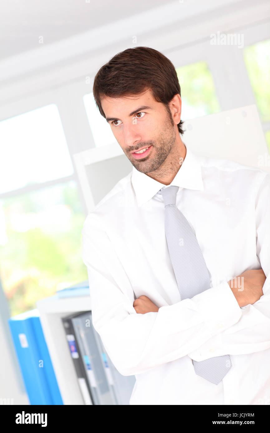 Portrait of businessman standing in office Stock Photo - Alamy