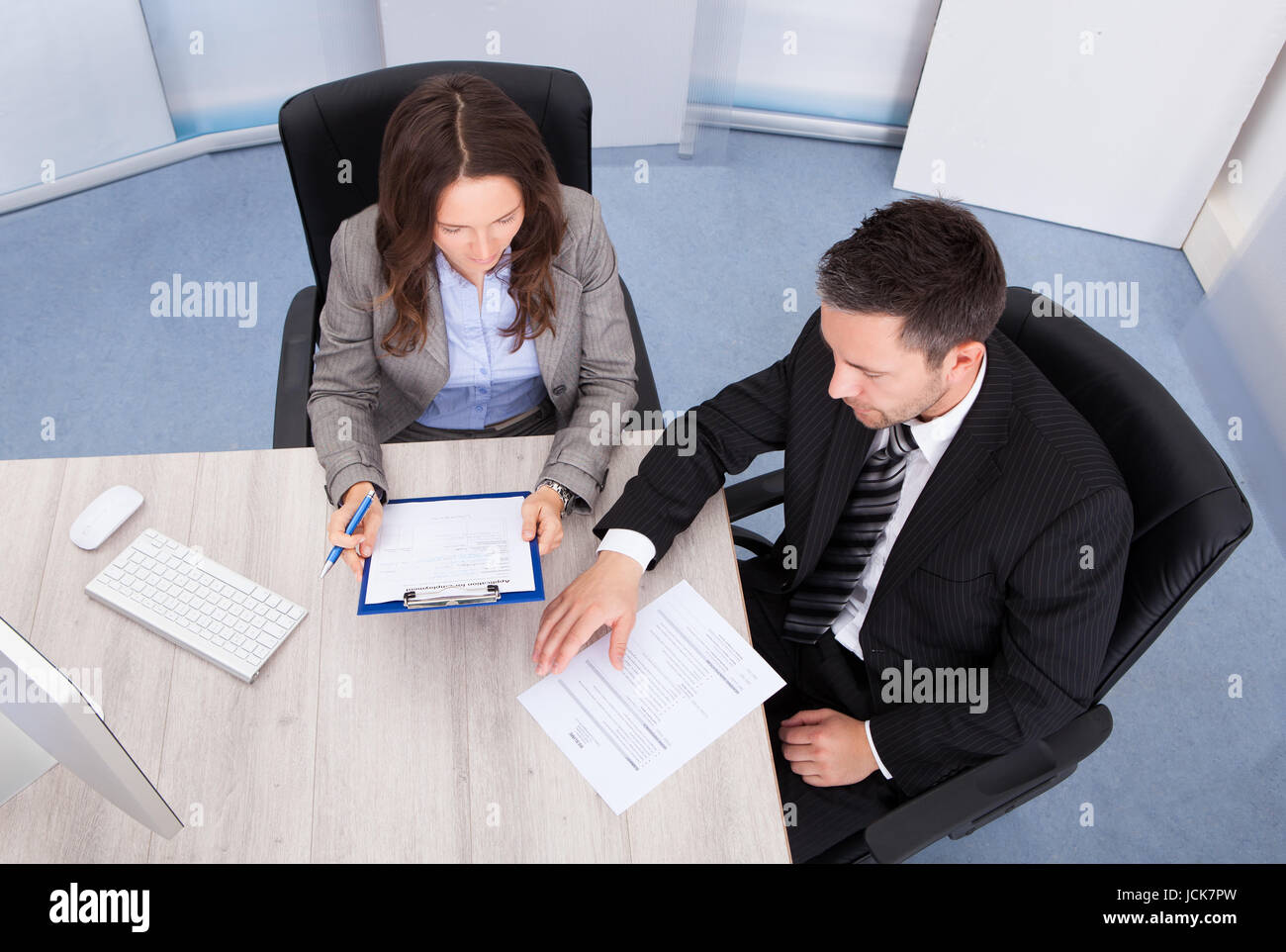 Man Looking At Businessman Writing On Clipboard Stock Photo - Alamy