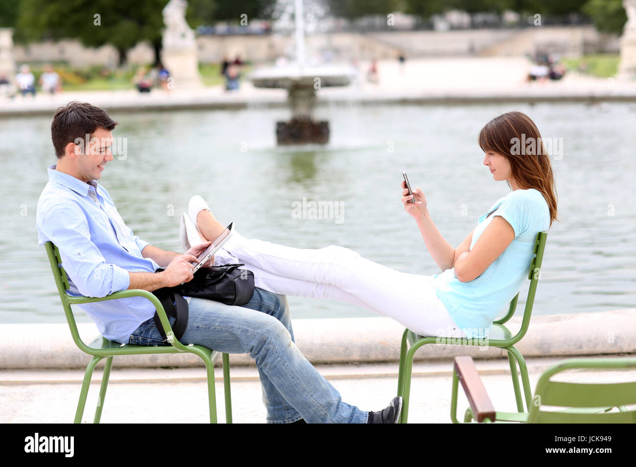 Couple relaxing in chairs in public park Stock Photo