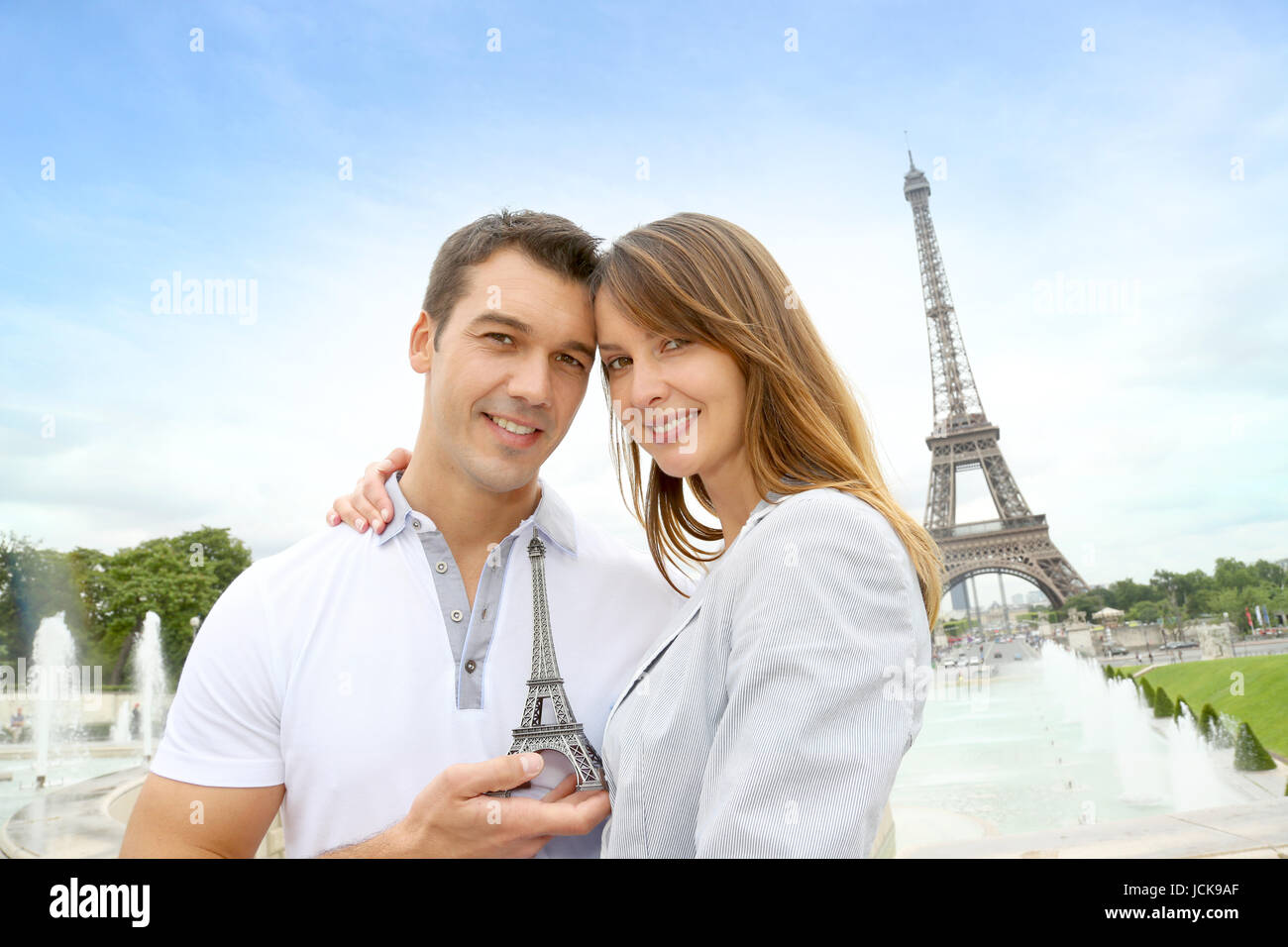 Couple Standing In Front Of The Eiffel Tower With Souvenir Stock Photo 