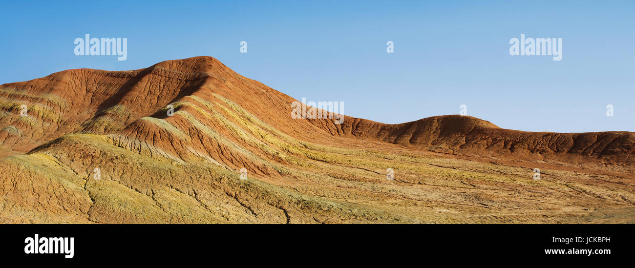 Striped shaped hills in desert with clear blue sky . Stock Photo