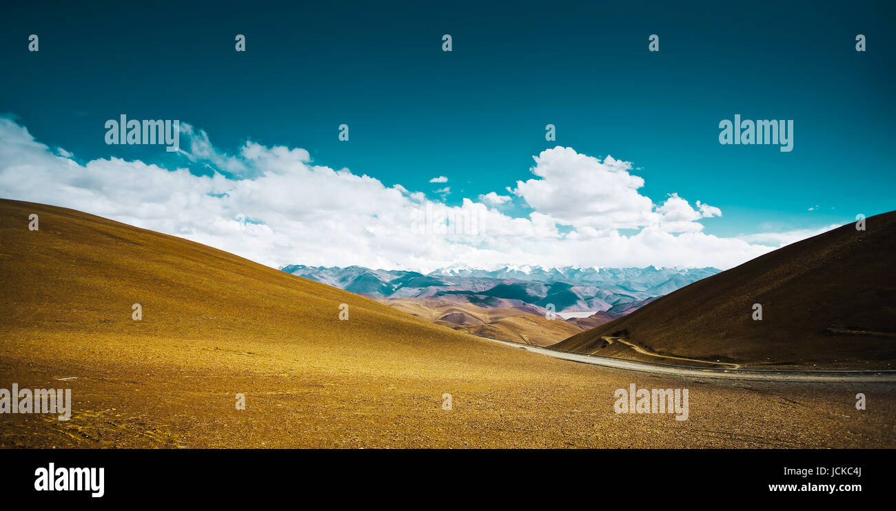 Beautiful scenery in Tibet with yellow hill  against blue and white clouds sky . Stock Photo