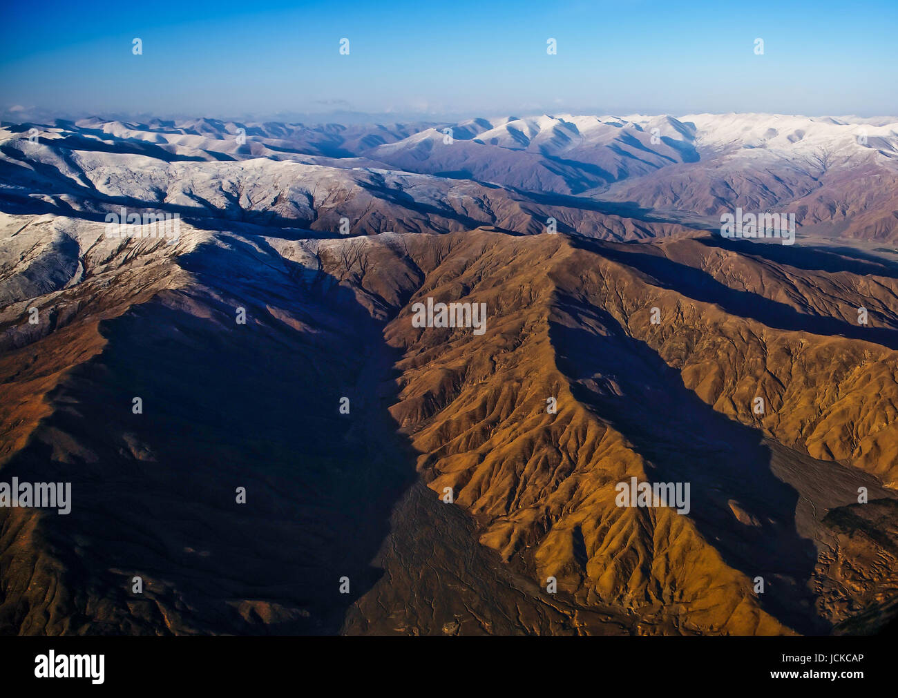 Beautiful scenery in Tibet with yellow hill and snowscape . aerial view . Stock Photo