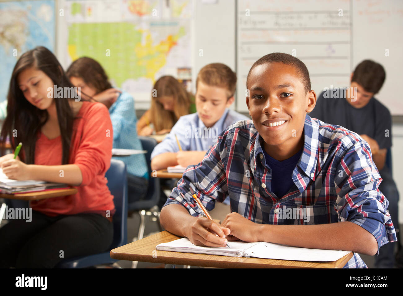 Portrait Of Male Pupil Studying At Desk In Classroom Stock Photo - Alamy