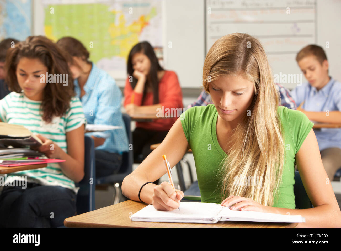 Female Pupil Studying At Desk In Classroom Stock Photo - Alamy