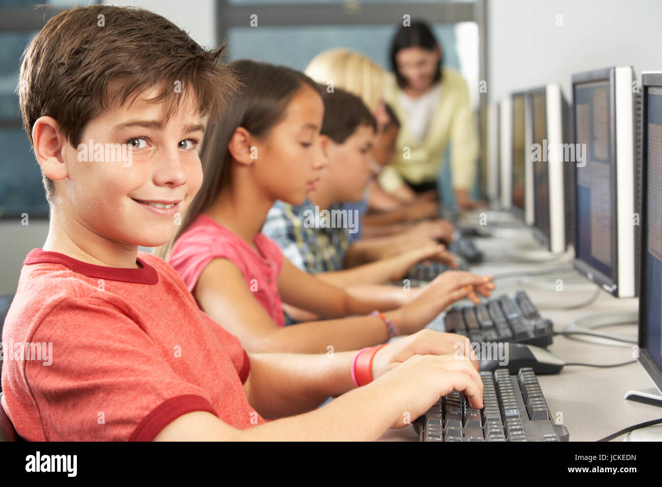 Elementary Students Working At Computers In Classroom Stock Photo Alamy