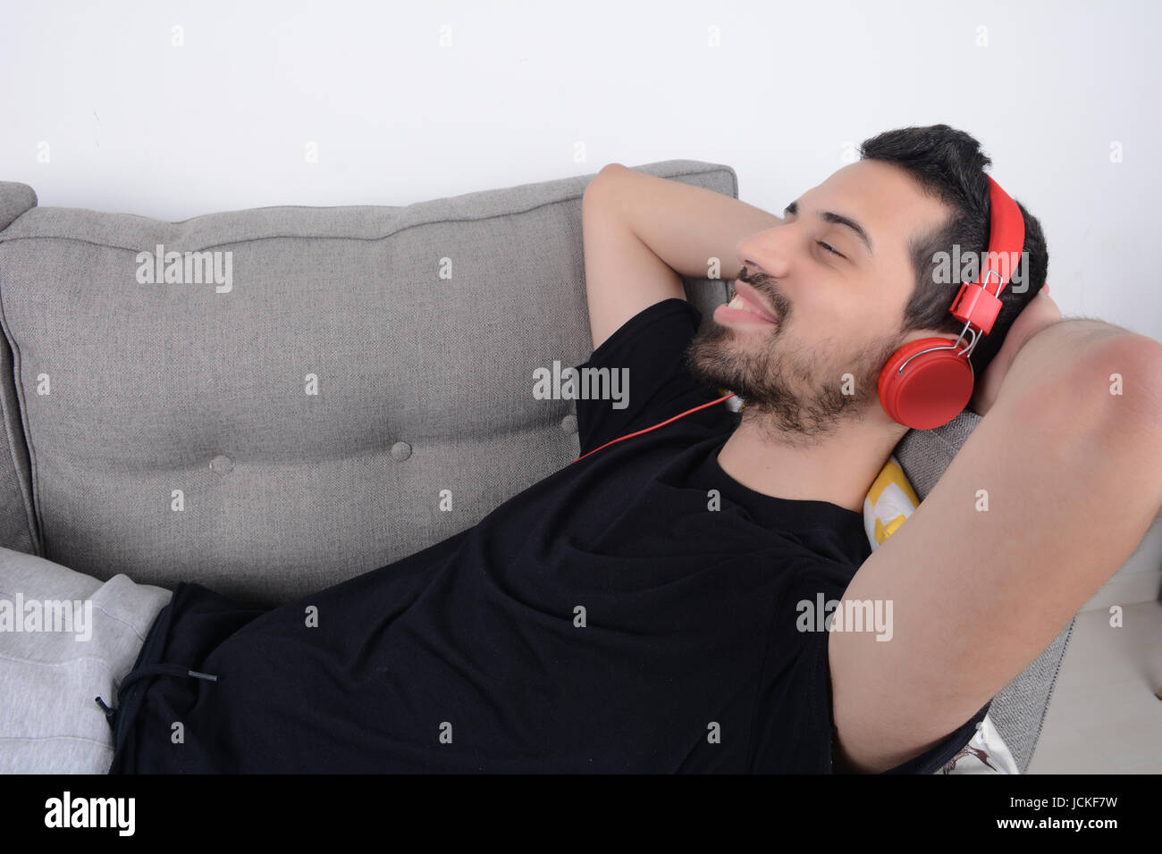 Attractive young man listening to music with headphones and relaxed on ...