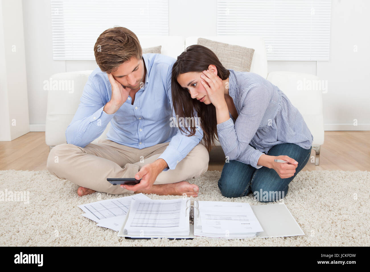 Unhappy young couple in financial trouble at home Stock Photo