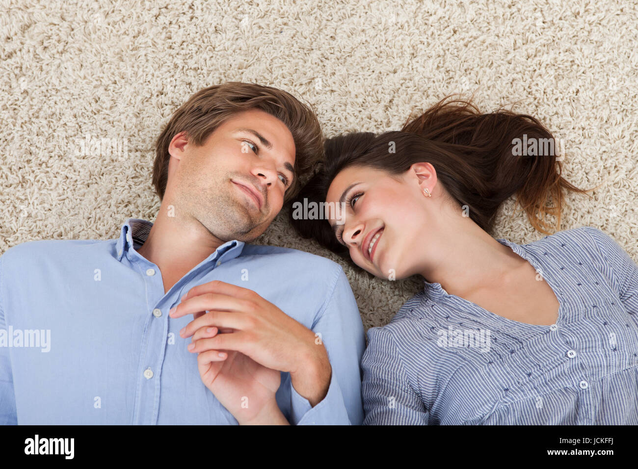 View While Other High angle view of loving couple looking at each other while lying on ...