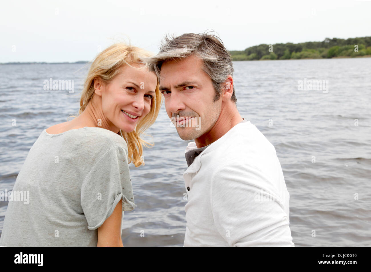Couple embracing each other on a bridge by a lake Stock Photo - Alamy