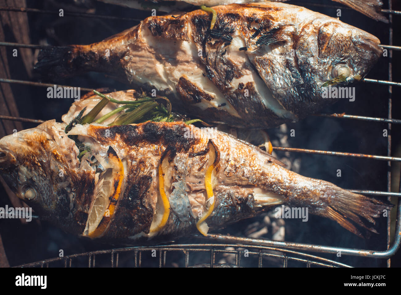 Grilled fish with lemon on the grid Barbeque in the garden in summer Stock Photo