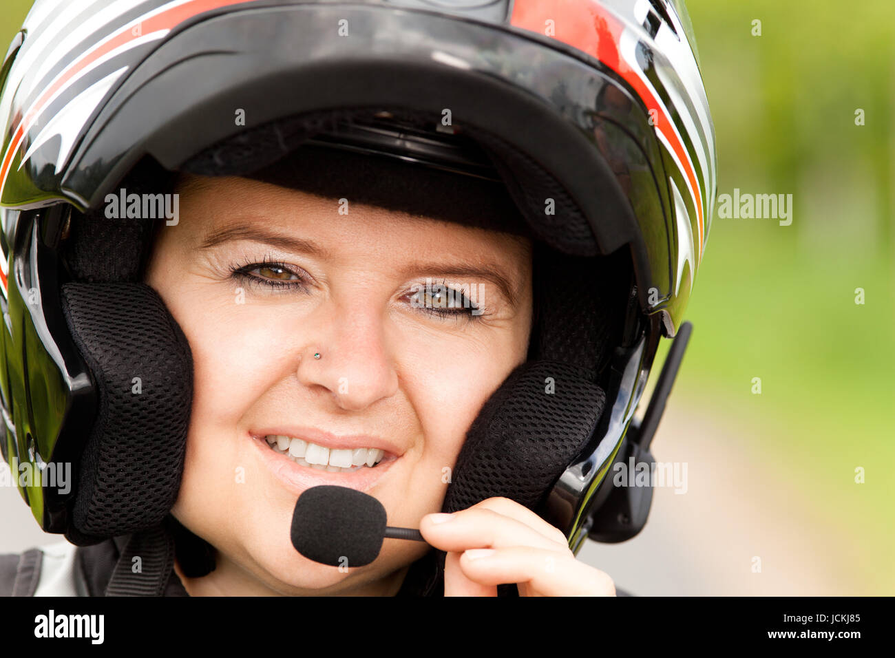 Motorradfahrerin mit Freisprechanlage Stock Photo