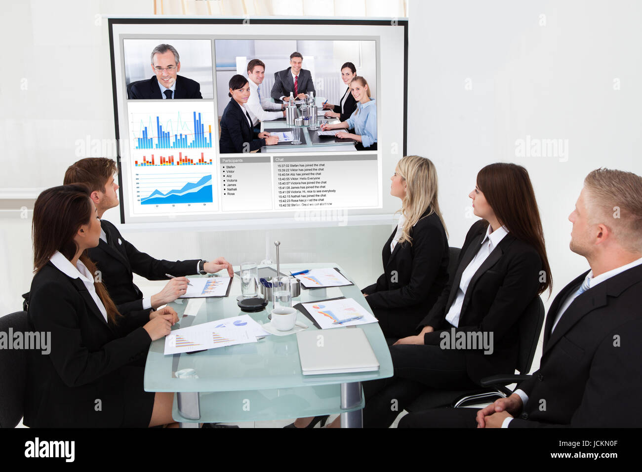Businesspeople looking at projector screen in video conference meeting