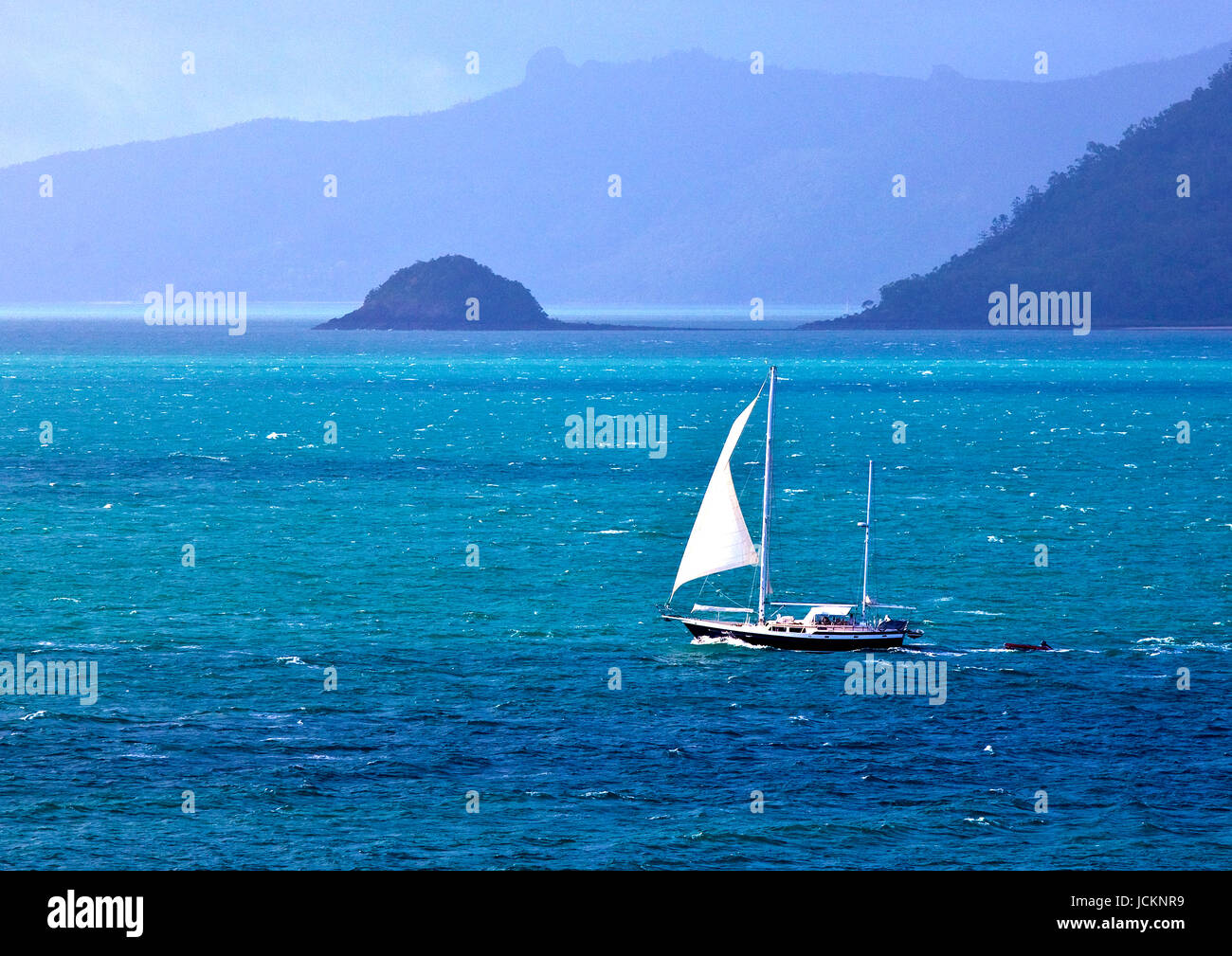 Lone yacht sails in the Whitsunay Passage off the Queensland coast Stock Photo